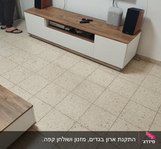 ארון טלוויזיה עם רמקולים ומסך תלוי על הקיר